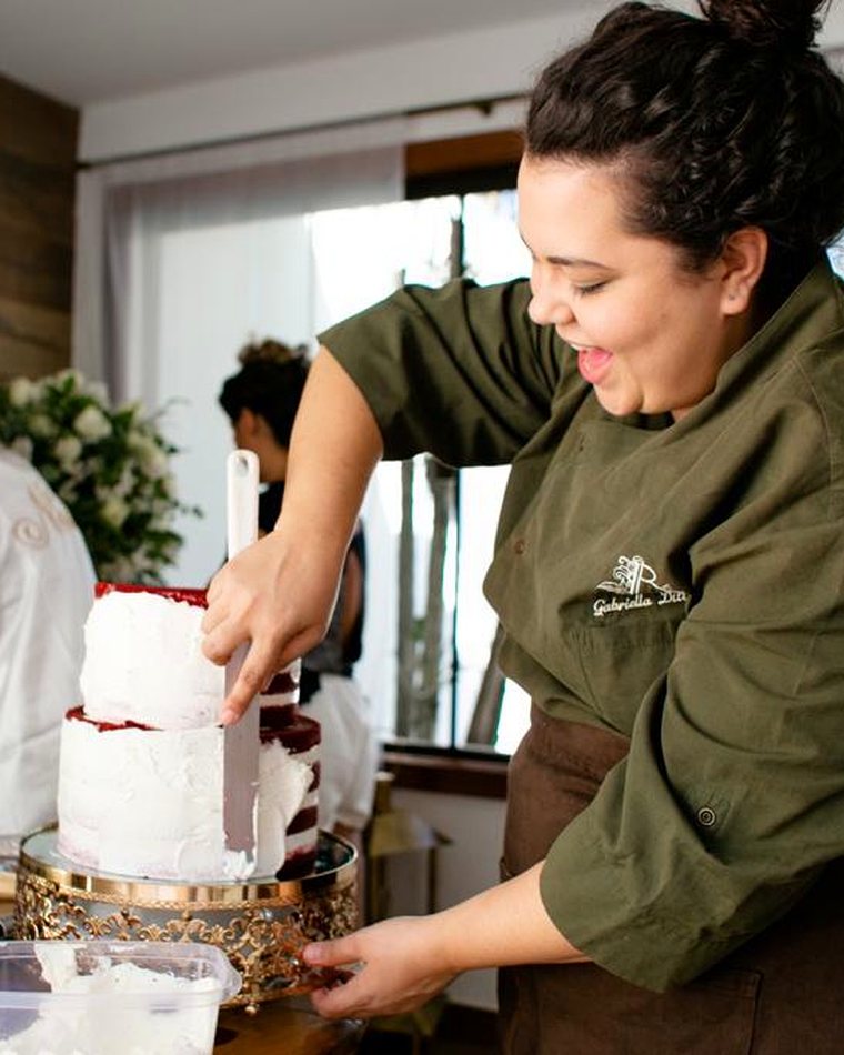 A chef no local, com a equipe do evento ao fundo