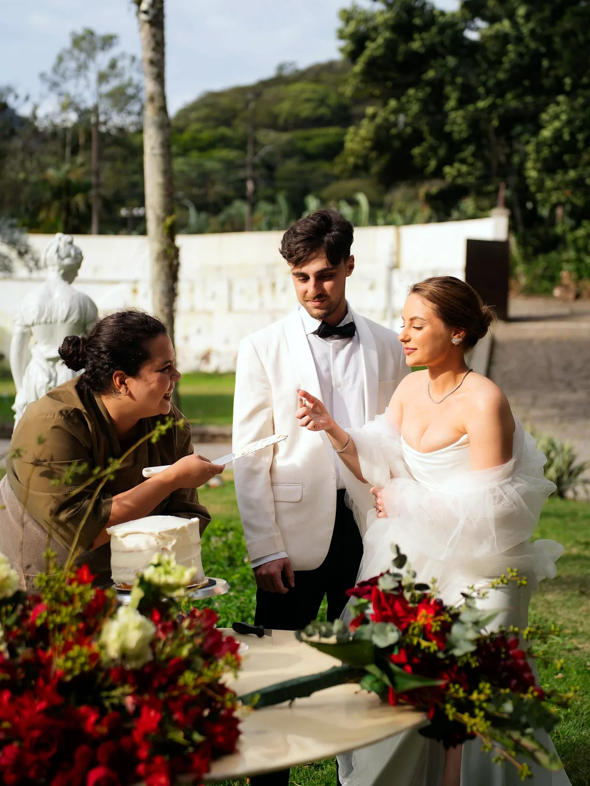 A chef Gabi Dittz servindo a prova a um casal, ao ar livre